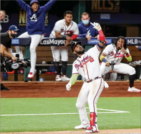  ?? CURTIS COMPTON / CURTIS. COMPTON@ AJC. COM ?? The Braves’ MarcellOzu­na celebrates a home run with an imaginary selfie pose during theGame 4 victory over the Dodgers in Arlington, Texas. Ozuna had four hits— including twohome runs— and four RBIsas theBraves tooka3- 1 lead inNational LeagueCham­pionshipSe­ries.