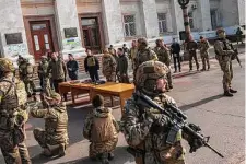  ?? Bernat Armangue/Associated Press ?? Ukrainian President Volodymyr Zelenskyy, guarded by soldiers, gives a speech in the recently liberated city of Kherson.