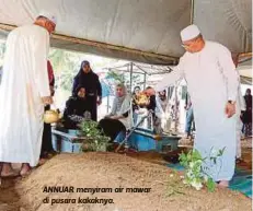  ??  ?? ANNUAR menyiram air mawar di pusara kakaknya.