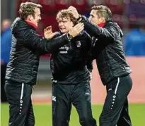  ??  ?? Geballte Freude: Stefan Krämer (Mitte) mit Co-trainer Ronny Hebestreit (rechts) und Torwarttra­iner René Twardzik nach dem Sieg.
Foto: Sascha Fromm