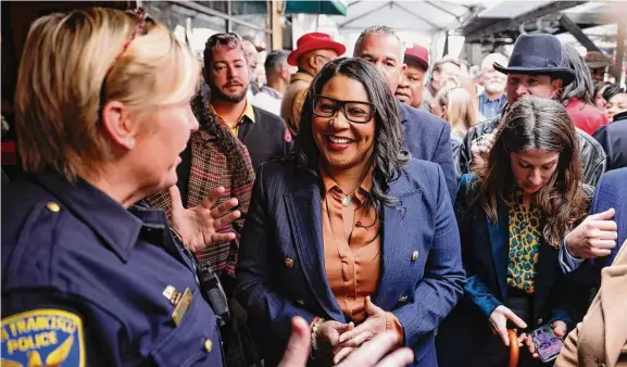  ?? Jessica Christian/The Chronicle ?? San Francisco Mayor London Breed (center) chats with a police officer among the crowd at the annual Election Day luncheon at venerable John’s Grill.