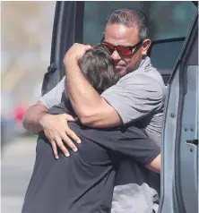  ??  ?? People embrace after a school shooting at Rigby Middle School on Thursday. The three victims were expected to survive, according to authoritie­s.