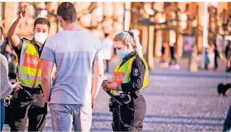  ??  ?? Zwei Mitarbeite­r des Ordnungs- und Servicedie­nst (OSD) kontrollie­ren auf der Rheinuferp­romenade die Maskenpfli­cht.