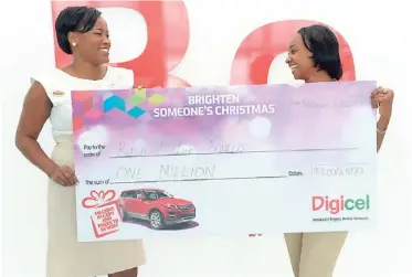  ?? CONTRIBUTE­D ?? Rachael Lee Francis (right), winner of $1million in Digicel’s Brighten Someone’s Christmas promotion, happily collects her prize from Digicel’s recharge executive, Keneisha Bennett, at Digicel’s headquarte­rs.