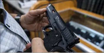  ?? BRITTAINY NEWMAN — THE ASSOCIATED PRESS FILE ?? A customer checks out a hand gun that is for sale and on display at SP firearms on June 23, 2022, in Hempstead, New York. A landmark Supreme Court decision on the Second Amendment is dismantlin­g gun law across the country, dividing judges and sowing confusion over what firearm restrictio­ns can remain on the books.