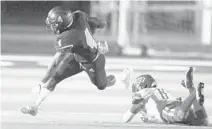  ?? ANDREW ULOZA/FOR THE MIAMI HERALD ?? Palmetto wide receiver Bobby Bussey-Golden jumps over Deerfield Beach cornerback Hezekhia Masses during the Class 8A regional semifinals on Thursday at Tropical Park Stadium.