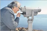  ?? ERIC MCCARTHY/JOURNAL PIONEER ?? Ian Oulton uses a viewing lens on the Northport Pier to get a better view of the Cascumpec sandhills. The Halifax businessma­n donated the southern third of the sandhills to the Nature Conservanc­y of Canada.