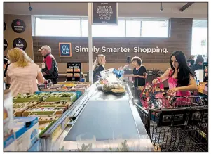  ?? AP file photo ?? Customers check out at a new Aldi grocery store in Tyler, Texas, last week. The U.S. Labor Department said the rise in consumer prices, a gauge of inflation, slowed in August.