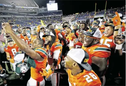  ?? GETTY IMAGES ?? Hurricanes players celebrate after their 31-14 Russell Athletic Bowl victory over West Virginia on Wednesday night in Orlando.