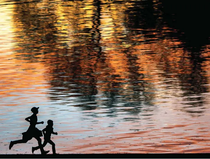  ??  ?? Two boys race along the Lewiston Levee Parkway Trail as the sunset shimmers on the Snake River, in Lewiston, Idaho. Photo: Pete Caster/Lewiston Tribune via AP