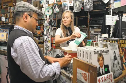  ?? Photos by Liz Hafalia / The Chronicle ?? Dennis Recio is assisted by bookseller Linnie Greene of Green Apple Books while making a purchase with a chip card.