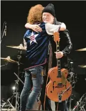  ?? EUGENE HOSHIKO/AP ?? Randy Bachman, right, and Takeshi embrace after Bachman was reunited with his stolen Gretsch guitar Friday at the Canadian Embassy in Tokyo.