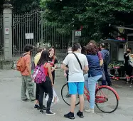  ??  ?? Un gruppo di cittadini davanti al cancello del giardino, in inutile attesa della sua apertura