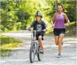  ?? STAFF FILE PHOTO BY ERIN O. SMITH ?? Isaac Wheatcroft, 7, rides his bike with Crystal Faudi running just behind him at Greenway Farm in Hixson.