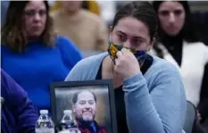  ?? Robert F. Bukaty/Associated Press ?? Rachael Sloat holds a framed photo of her fiance, Peyton Brewer Ross, as she testifies Feb. 1 in Augusta, Maine, during a hearing investigat­ing the law enforcemen­t response to the mass shooting in which he died.