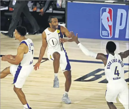  ?? KIM KLEMENT - THE ASSOCIATED PRESS ?? Indiana Pacers forward T.J. Warren (1) celebrates with guards Malcolm Brogdon (7) and Victor Oladipo (4) after a play against the Los Angeles Lakers during an NBA basketball game Saturday, Aug. 8, 2020, in Lake Buena Vista, Fla.