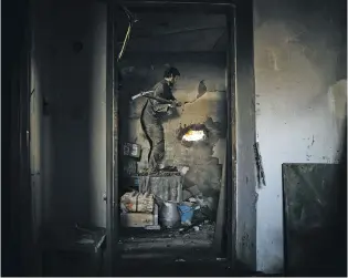  ?? TYLER HICKS/THE NEW YORK TIMES ?? A Ukrainian soldier with the 11th Separate Motorized Infantry Battalion breaks open a hole to take a firing position on the outskirts of Donetsk, Ukraine, in February.