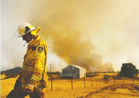  ?? SAM MOOY/ GETTY IMAGES FILES ?? A firefighte­r attends to fires last month in the small town of Tumbarumba in Australia. Amid the devastatio­n of wildfires and drought, there’s innovation, with distillers, brewers and winemakers considerin­g ways to use the tainted grapes to create new products.