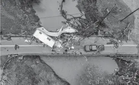  ?? Ryan C. Hermens/associated Press ?? People work to clear a house from a bridge near the Whitesburg Recycling Center in Letcher County, Ky., on Friday. Record flash flooding has prompted a frantic search for survivors in entirely swamped towns.