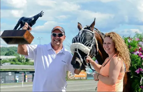  ?? Pam Panchak/Post-Gazette photos ?? Jessica Okusko, trainer for Dude's The Man, celebrates in the winner’s circle with her husband, Howard, after her horse won the Delvin Miller Adios Pace for the Orchids at The Meadows.