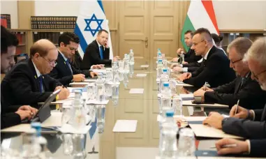  ?? (Diaspora Affairs Ministry) ?? HUNGARIAN FOREIGN Minister Péter Szijjártó (R) sits across from Diaspora Affairs and Combating Antisemiti­sm Minister Amichai Chikli in Budapest, Hungary, on Monday.