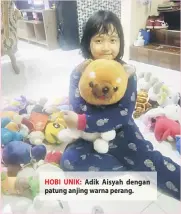  ??  ?? HOBI UNIK: Adik Aisyah dengan patung anjing warna perang.