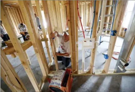  ?? GERALD HERBERT — THE ASSOCIATED PRESS ?? In this Friday photo, Chris Piazza, an electricia­n with Tasch Electric, works on a home being built by Zach Tyson of Tyson Constructi­on, in Destrahan, La. Tyson estimates that between 30 percent and 40 percent of his revenue is coming from boomer...