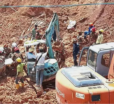  ?? — AP ?? Working against time: Rescuers carrying the body of a victim after he was pulled out from the debris of the landslide in Tanjung Bungah, Penang. ( Top right) A stream running through the site of the tragedy.