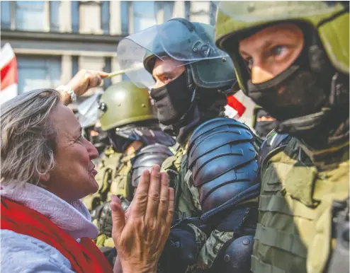  ?? TUT.BY/AFP VIA GETTY IMAGES FILES ?? A protester tries to speak with a Belarusian serviceman as opposition supporters rally to protest
against disputed presidenti­al elections results in Minsk last year.