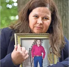  ??  ?? Una mUjer con la foto de su hijo victimado por la banda