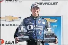  ?? PRESS] [CARLOS OSORIO/THE ASSOCIATED ?? Graham Rahal holds the trophies from the Detroit Grand Prix last weekend. He won both races.