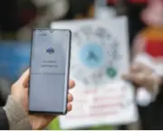  ??  ?? A person scans a QR code at the gate of a community before entering as a preventive measure based on big data in Kunming, Yunnan Province in southwest China, on February 15