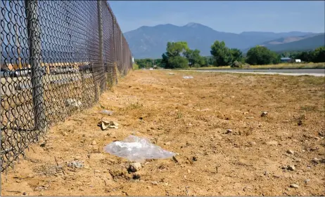  ?? WILL HOOPER/Taos News ?? A single use plastic bag lays near the Taos High School fence along Gusdorf Road.
