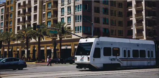  ?? DAI SUGANO — STAFF ARCHIVES ?? A VTA light rail train passes an apartment complex in North San Jose in 2019. Deep service cuts are being considered.