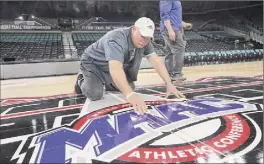  ?? Edward Lea / Associated Press ?? Bill Gannon, a carpenter from Local No. 255, puts the finishing touches on the court for the MAAC Tournament in Atlantic City, N.J.