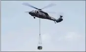  ?? Ned Gerard / Hearst Connecticu­t Media ?? A Sikorsky UH-60A Black Hawk helicopter hovers with a payload at Sikorsky Memorial Airport in Stratford last July.