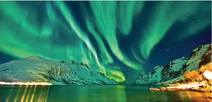  ?? ?? TIMELESS BEAUTY: The mesmerisin­g aurora borealis lighting up the sky above Norway’s fjords