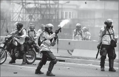 ?? AP/ FERNANDO LLANO ?? A police officer fires tear gas to disperse anti- government protesters Thursday in Caracas, Venezuela.