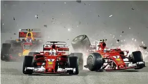 ?? — AP ?? Crash, boom, bang: Ferrari driver Kimi Raikkonen (right) of Finland colliding with teammate Sebastian Vettel of Germany at the start of the race.