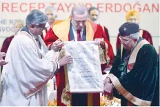  ?? — AFP ?? Turkish President Recep Tayyip Erdogan and Prime Minister Narendra Modi greet each other after an exchange of agreements during a joint press conference in New Delhi. (Right) Erdogan displays the honorary degree he received from Jamia Millia Islamia...