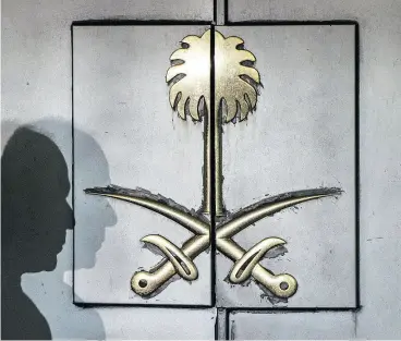  ?? YASIN AKGUL / AFP / GETTY IMAGES ?? The silhouette of a security guard is seen Friday on the entrance door of the Saudi Arabia’s consulate in Istanbul where missing journalist Jamal Khashoggi was last seen.