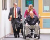  ?? COURTESY OF FARMINGTON DAILY TIMES ?? Bobby Willis is wheeled to Farmington District Court last year by his ex-wife Carrie Willis, escorted by his attorney Bob Cooper.