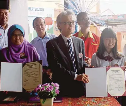  ?? [FOTO NURUL AMANINA SUHAINI /BH] ?? Rosliza dan Tsutomu bertukar dokumen selepas menandatan­gani MOU sebagai simbolik pertukaran budaya sempena Program Lawatan Pengantara­bangsaan Sekolah Tinggi Matsue Jyoshi di SMK Kempas, Johor Bahru, semalam.