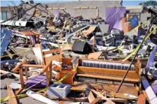  ?? ?? Right: A piano and debris are seen in the sanctuary of Community Baptist Church