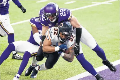  ?? STEPHEN MATUREN/GETTY ?? David Montgomery rushes for a third quarter touchdown as Jeff Gladney (20) and Harrison Smith (22) of the Minnesota Vikings are unable to make the stop.