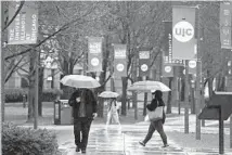  ?? JOHN J. KIM/CHICAGO TRIBUNE ?? People walk under umbrellas on the University of Illinois at Chicago campus on March 30.