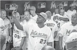  ?? AL DIAZ/MIAMI HERALD ?? Former catcher Charles Johnson takes a selfie with players from the inaugural and World Series teams in the dugout before Saturday’s game with the San Diego Padres at Marlins Park.