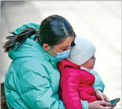 ?? AFP ?? A woman holds her toddler in Shanghai on February 24. A 2019 report by a government-affiliated research institute estimated China had more than 19 million single mothers, including divorcees and widows.