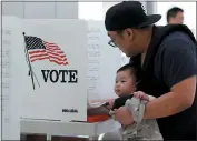  ?? ANDA CHU - STAFF PHOTOGRAPH­ER ?? Thien Dinh brought his 5-month-old son Bruce along as he cast his ballot at a polling place inside Levi’s Stadium.