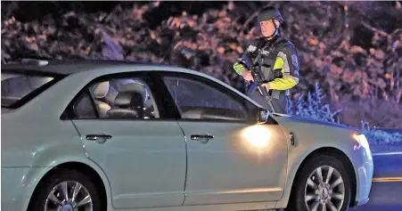  ?? STAFF PHOTOS BY MATT STONE ?? WANTED: Scituate police stop cars from traveling on Route 3A in Marshfield as police search for a man suspected of murdering his wife yesterday, according to Plymouth District Attorney Tim Cruz, right.